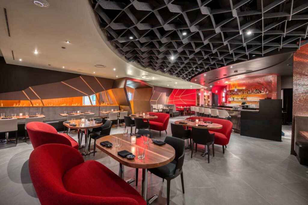 interior of a sushi restaurant with red seating and black ceilings